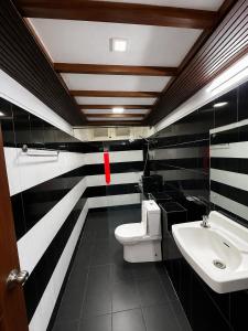 a bathroom with a white toilet and a sink at Subhas Tourist Hotel in Jaffna +36 photos