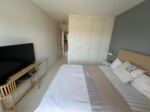 a bedroom with a bed and a flat screen tv at Condo with golf course views, pool and terraces in San Jorge