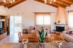 a living room with a table and chairs and a couch at Agapi's House in Kanali