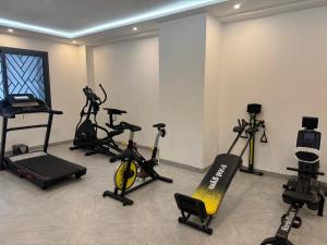 ein Fitnessstudio mit mehreren Heimtrainern in einem Raum in der Unterkunft Emeraude avec salle de sport in Dakar