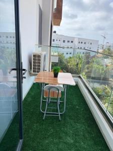 ein Tisch und Stühle auf einem Balkon mit grünem Rasen in der Unterkunft Emeraude avec salle de sport in Dakar + 4 Fotos