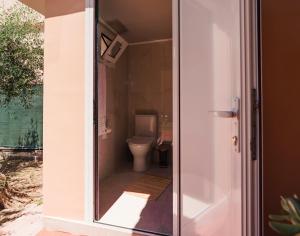 a bathroom with a toilet and a door open at Agapi's House in Kanali +55 photos