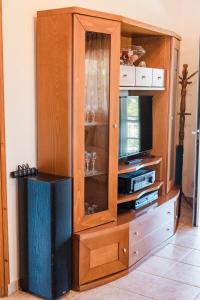 a wooden entertainment center with a tv and a cabinet at Agapi's House in Kanali