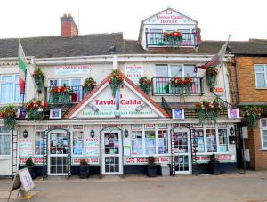un edificio con flores en la parte delantera en La Tavola Calda Hotel, en Nuneaton