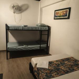 a room with two bunk beds and a fan at Hostal Nomadas in Santa Marta