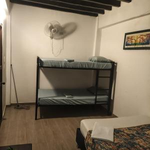 a room with two bunk beds and a fan at Hostal Nomadas in Santa Marta
