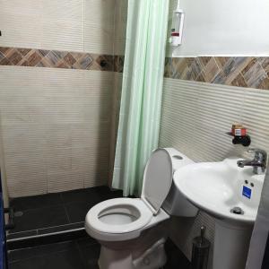 a bathroom with a toilet and a sink at Hostal Nomadas in Santa Marta