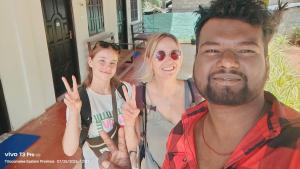 a man and two women making the peace signs with their hands at TJ JANSE guest inn in Trincomalee +24 photos