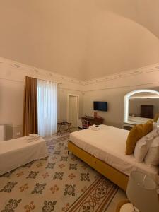 a hotel room with two beds and a mirror at Bellavitarooms-Fiore di Maggio Luxury Suites in Matera