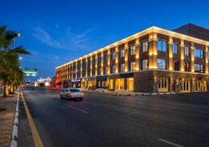 a car driving down a street in front of a building at Leaf Suites - أجنحة ليف in Ar Rass