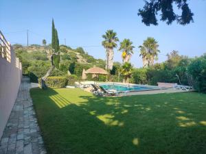 a yard with a swimming pool and palm trees at Falfeira Apartments in Lagos