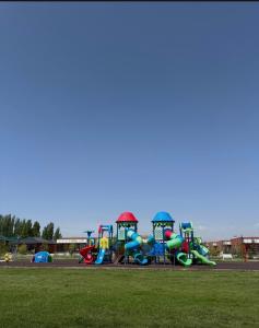 a park with a playground with colorful slides at Alpha White Resort in Koshkolʼ