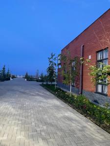 an empty street next to a brick building at Alpha White Resort in Koshkolʼ