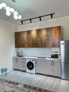 a kitchen with white appliances and wooden cabinets at Alpha White Resort in Koshkolʼ