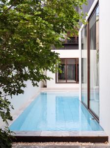 a swimming pool in the middle of a house at Qabalah Villa Private Pool & Rooftop Garden Stylish 2BR Retreat near Bang Tao in Ban Pak Lak