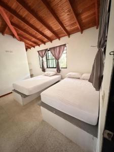 a bedroom with two beds and a window at Finca Hotel Villa Alba in San Jerónimo