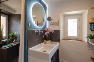 a bathroom with a sink and a mirror at Duplex Terrasse Jacuzzi Privatif & Vue Cévennes in Saint-Jean-du-Gard +10 photos