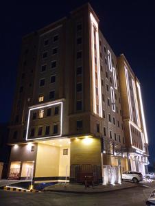 a large building with lights on it at night at Sendan Residence in Dammam