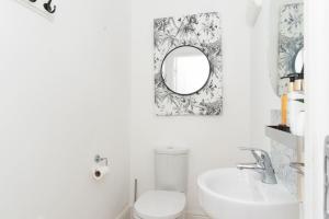 a bathroom with a white toilet and a mirror at Convenient & cosy 3 bed house in Newport +32 photos