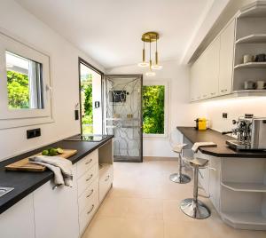 a kitchen with white cabinets and black counter tops at Nina Apartment in Ágios Márkos
