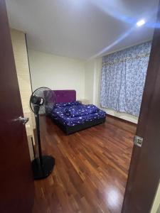 a small room with a couch and a fan at Anjung Seri Residence in Masai +4 photos