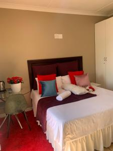 a bedroom with a large bed with colorful pillows at Ecogreen on OR Tambo in Kempton Park