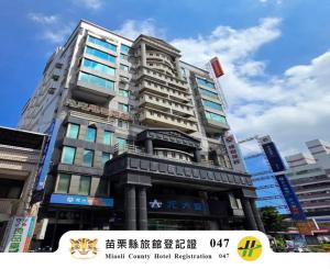 a tall building in the middle of a city at Green Yard Business Hotel in Miaoli