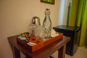 a wooden table with a bottle and glasses on it at Eco Serenity Kandy in Kandy