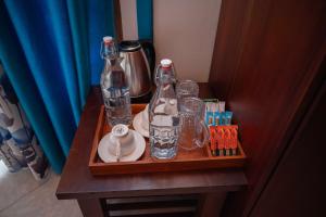 a wooden tray with glass bottles and plates on a table at Eco Serenity Kandy in Kandy +9 photos