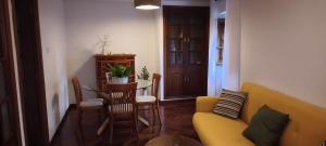 a living room with a yellow couch and a table at O retiro da Trabe in Viveiro