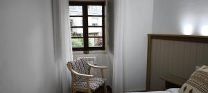 a bedroom with a chair and a window at O retiro da Trabe in Viveiro +23 photos