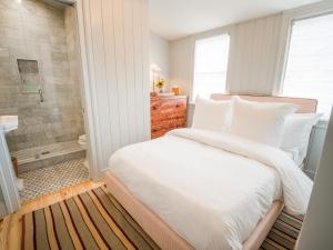 a bedroom with a large white bed and a bathroom at Sawyer House in Nantucket +67 photos