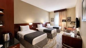 a hotel room with two beds and a television at Makarem Mina Hotel in Mecca +33 photos