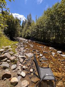 a chair sitting on the rocks in a creek at Privet creek side glamping in Chase +2 photos