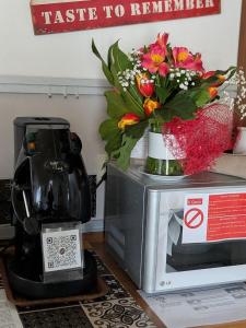 a vase of flowers sitting on top of a microwave at Il Geco in Matera