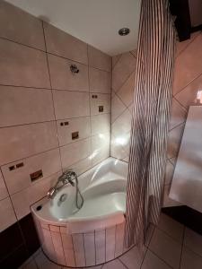 a bath tub with a faucet in a bathroom at Apartament przy Wyspie in Piła