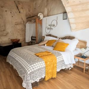a bedroom with a large bed with yellow pillows at Il Geco in Matera