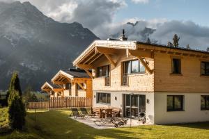 a house in the mountains with a table and chairs at Wilderer Chalets in Leutasch