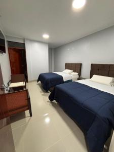 a hotel room with two beds and a chair at La Ruta in Paracas +41 photos