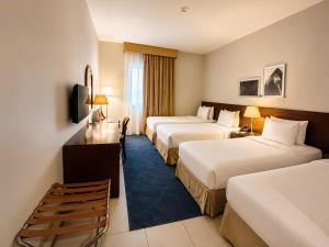 a hotel room with two beds and a desk at Makarem Al Bait Al Azizia Hotel in Mecca +23 photos