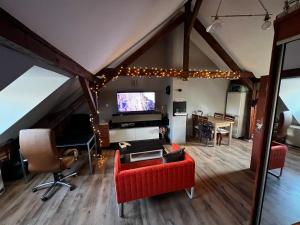 a living room with a red couch and a piano at Apartament przy Wyspie in Piła