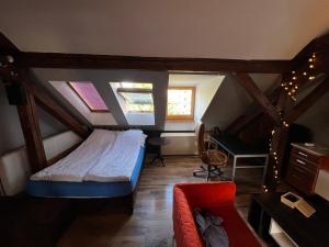 a bedroom with a bed and a desk in a attic at Apartament przy Wyspie in Piła