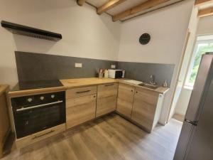 a kitchen with wooden cabinets and a sink and a stove at Duplex des Volcans in Montaigut-le-Blanc