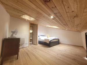 a bedroom with a bed and a wooden ceiling at Duplex des Volcans in Montaigut-le-Blanc