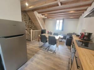 a kitchen and a living room with a table and chairs at Duplex des Volcans in Montaigut-le-Blanc