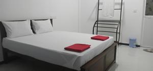 a white bed with two red towels on it at Sivas friendly guest house in Nilaveli