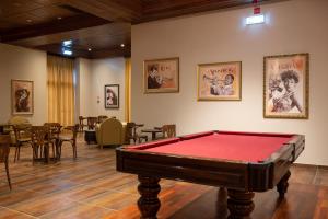 a pool table in a room with tables and chairs at Vila Gale Porto - Centro in Porto