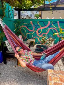 a woman laying in a hammock in front of a wall at Drift Inn San Pedro in San Pedro