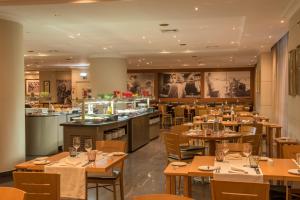 a restaurant with wooden tables and chairs and a bar at Vila Gale Porto - Centro in Porto