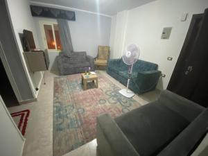a living room with a couch and chairs and a fan at الملاحه in Suez